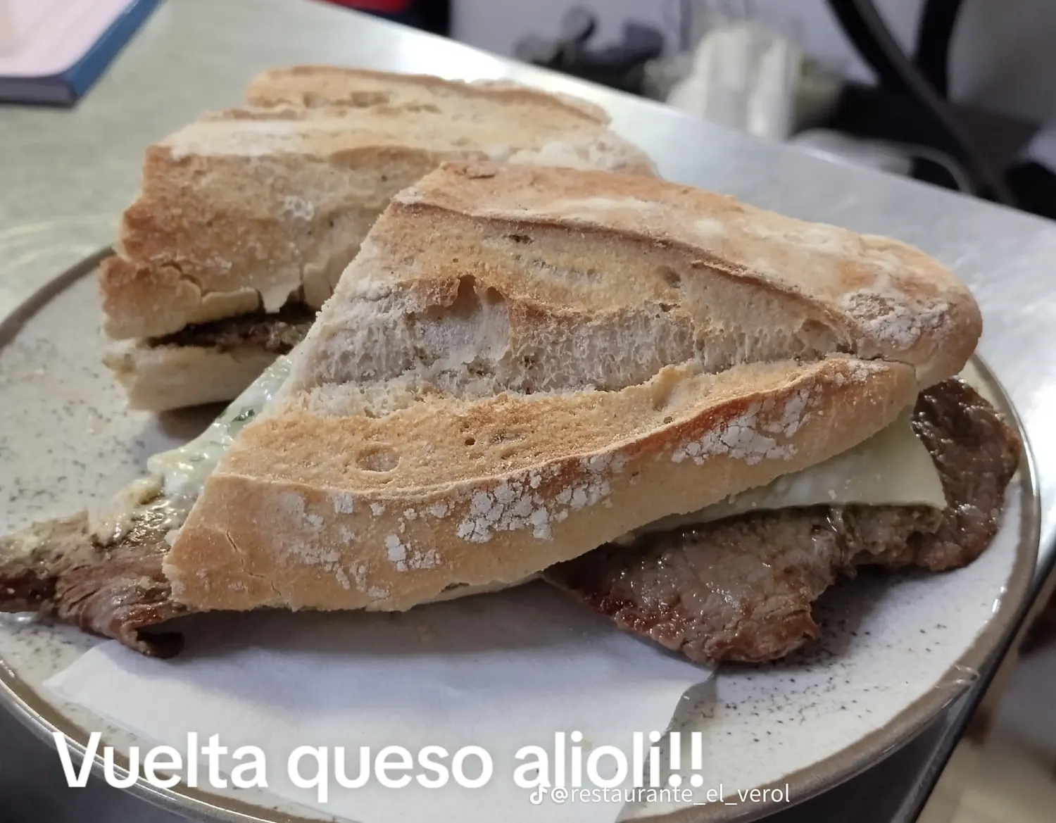 Bocadillo de vuelta con queso y alioli en un plato